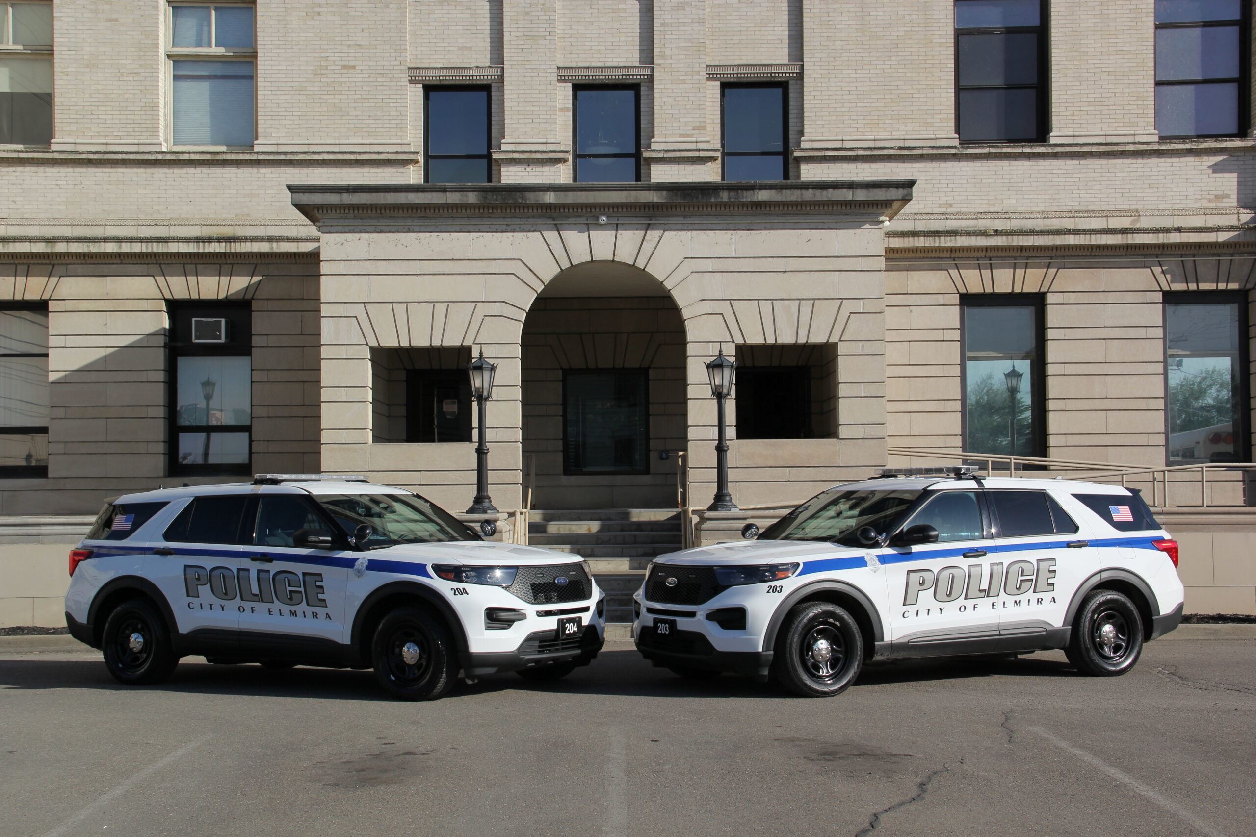 Two police cruisers parked in front of station