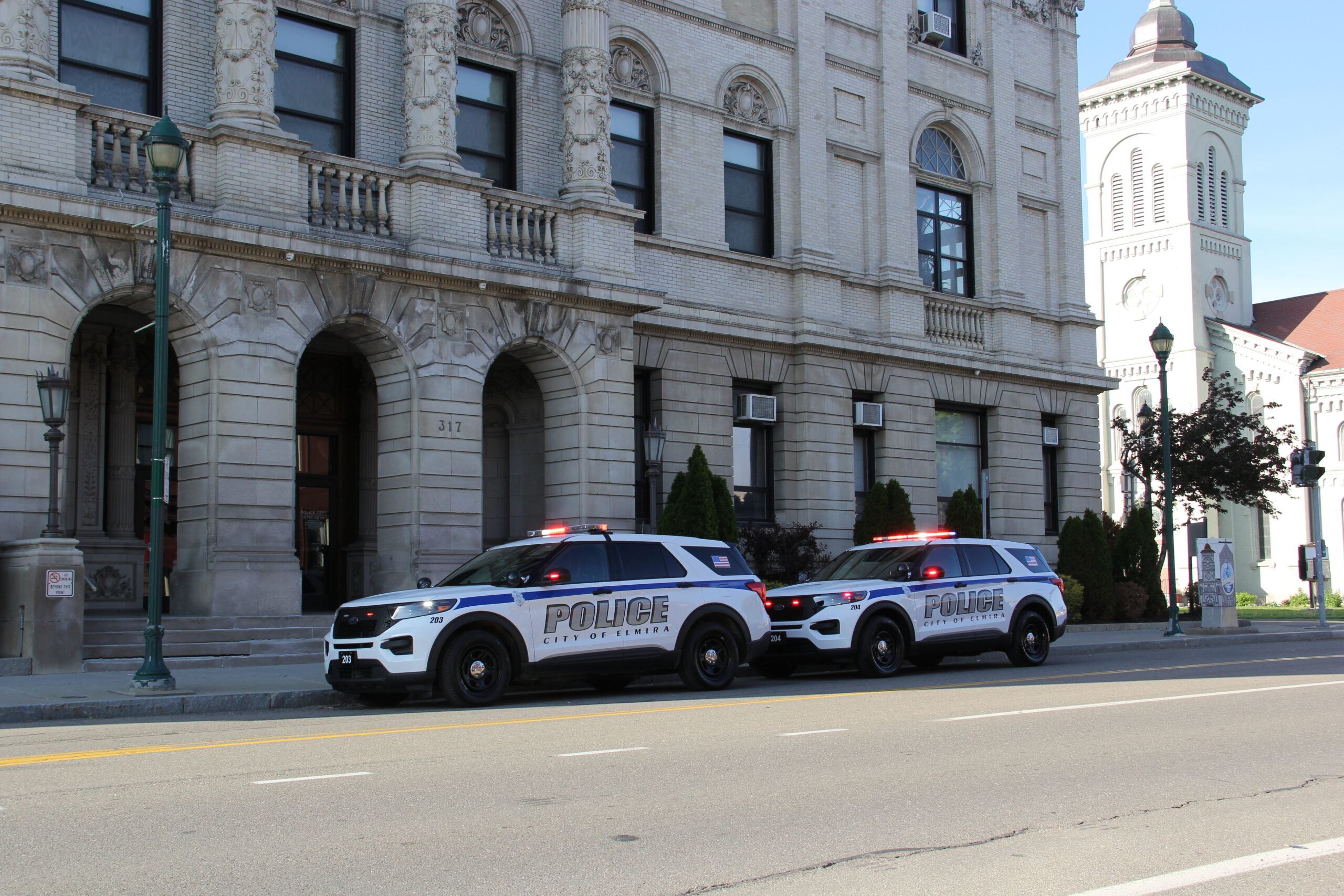 Two cop cars outside of the police station