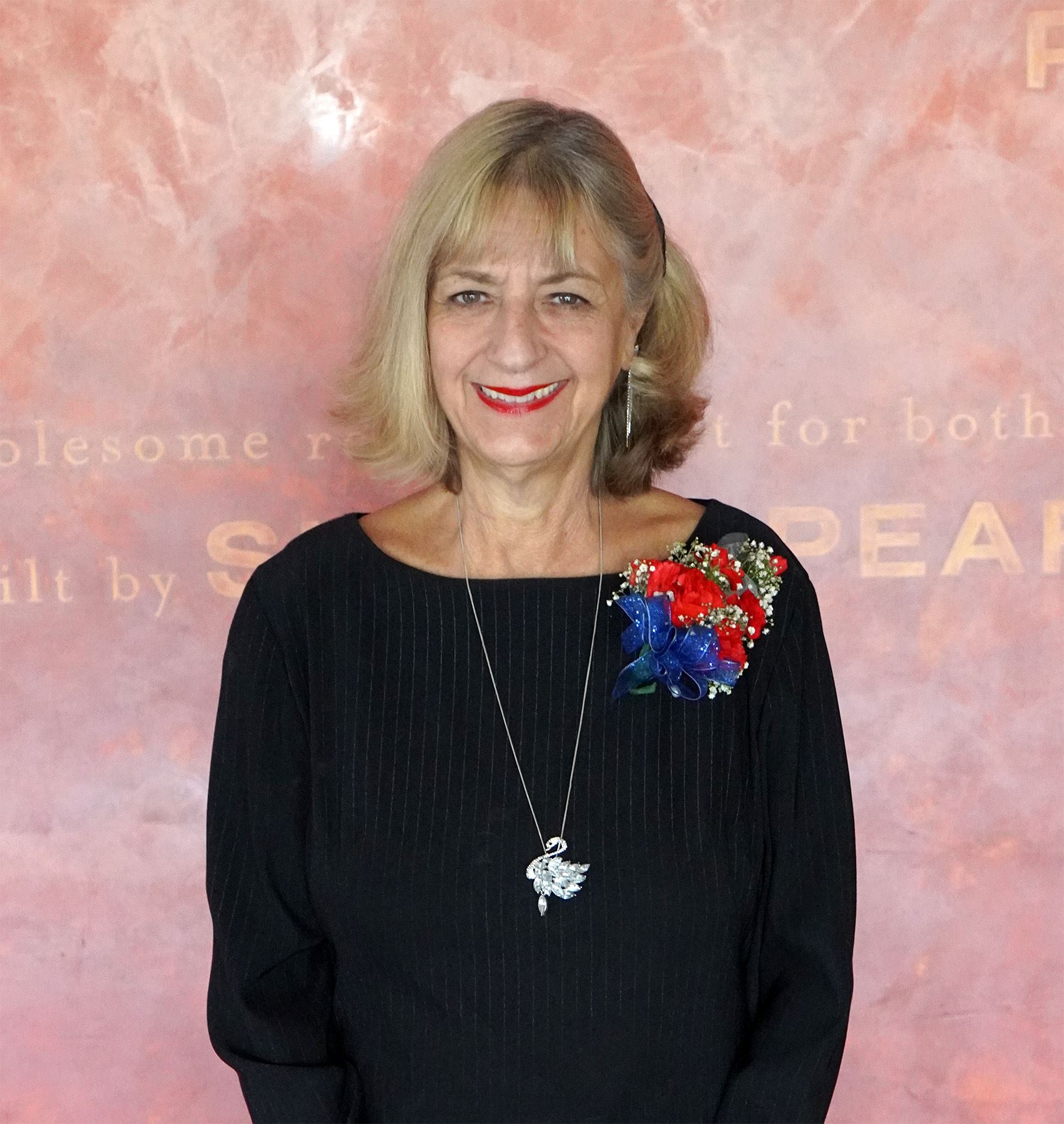 Short white female wearing black with blonde hair smiling