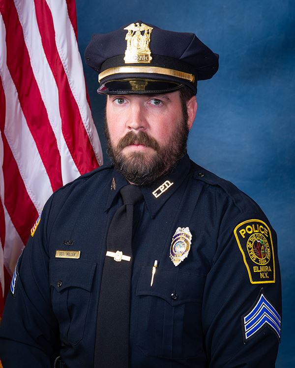 Miller David - white male - brown hair - brown beard and mustache - police uniform - green eyes 
